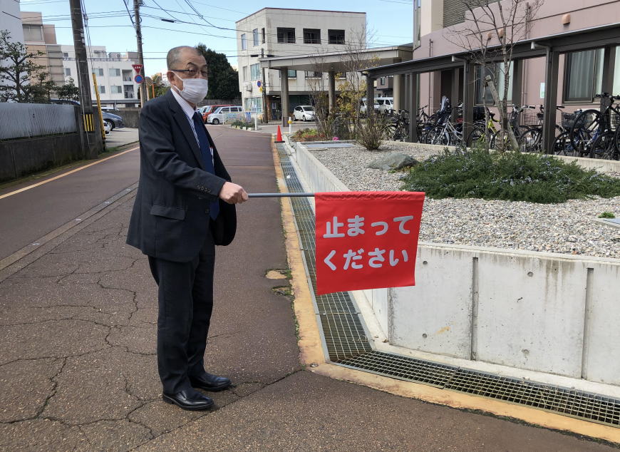とまってください旗を持って立つ社長