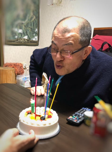 ケーキのローソクを消す社長