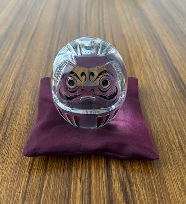 紫のチュールの座布団の上にダルマを乗せてみる