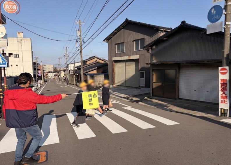 朝、横断歩道で児童を誘導している松本君。